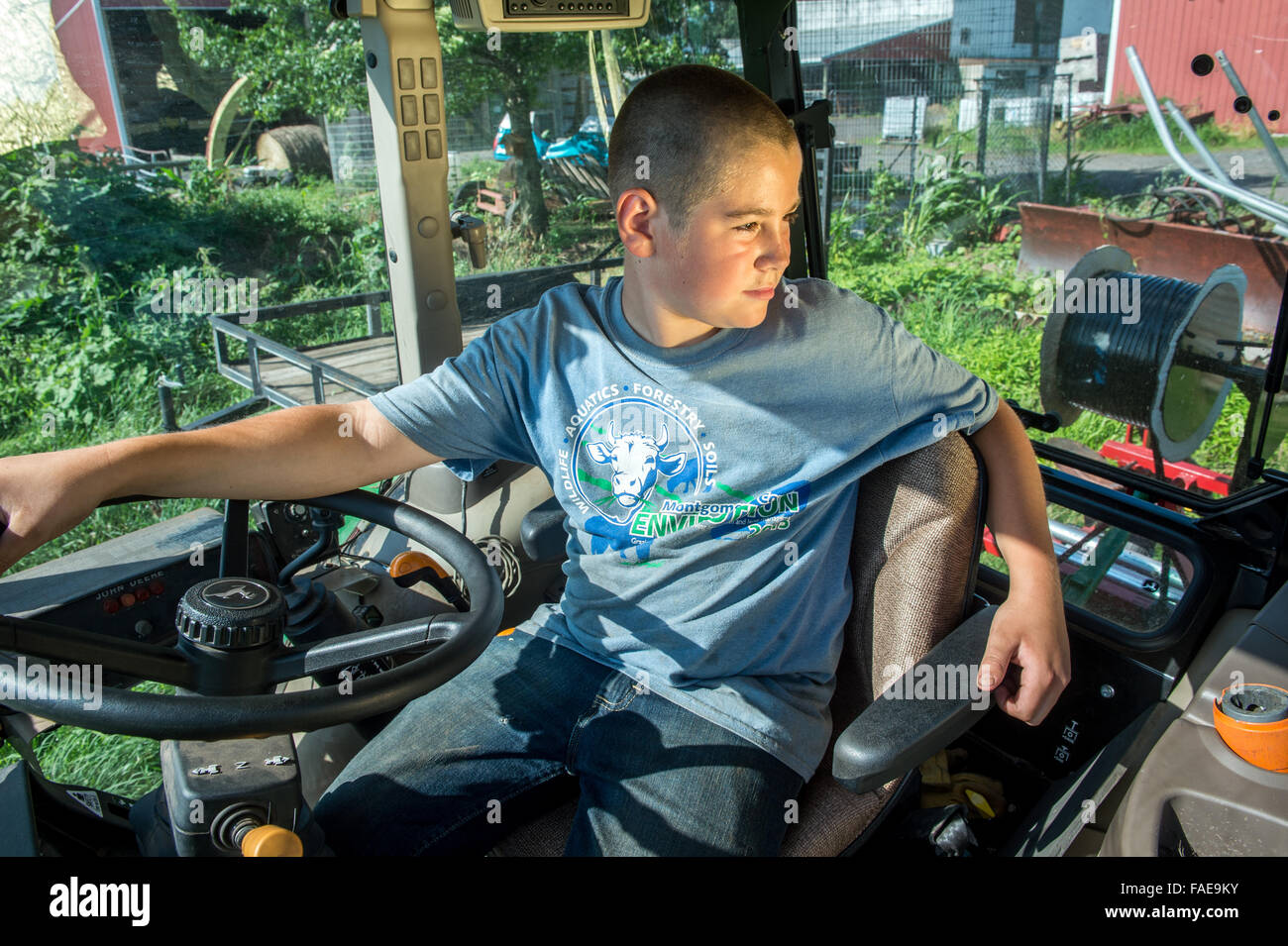 Young boy sitting in the drivers seat of a tractor Stock Photo