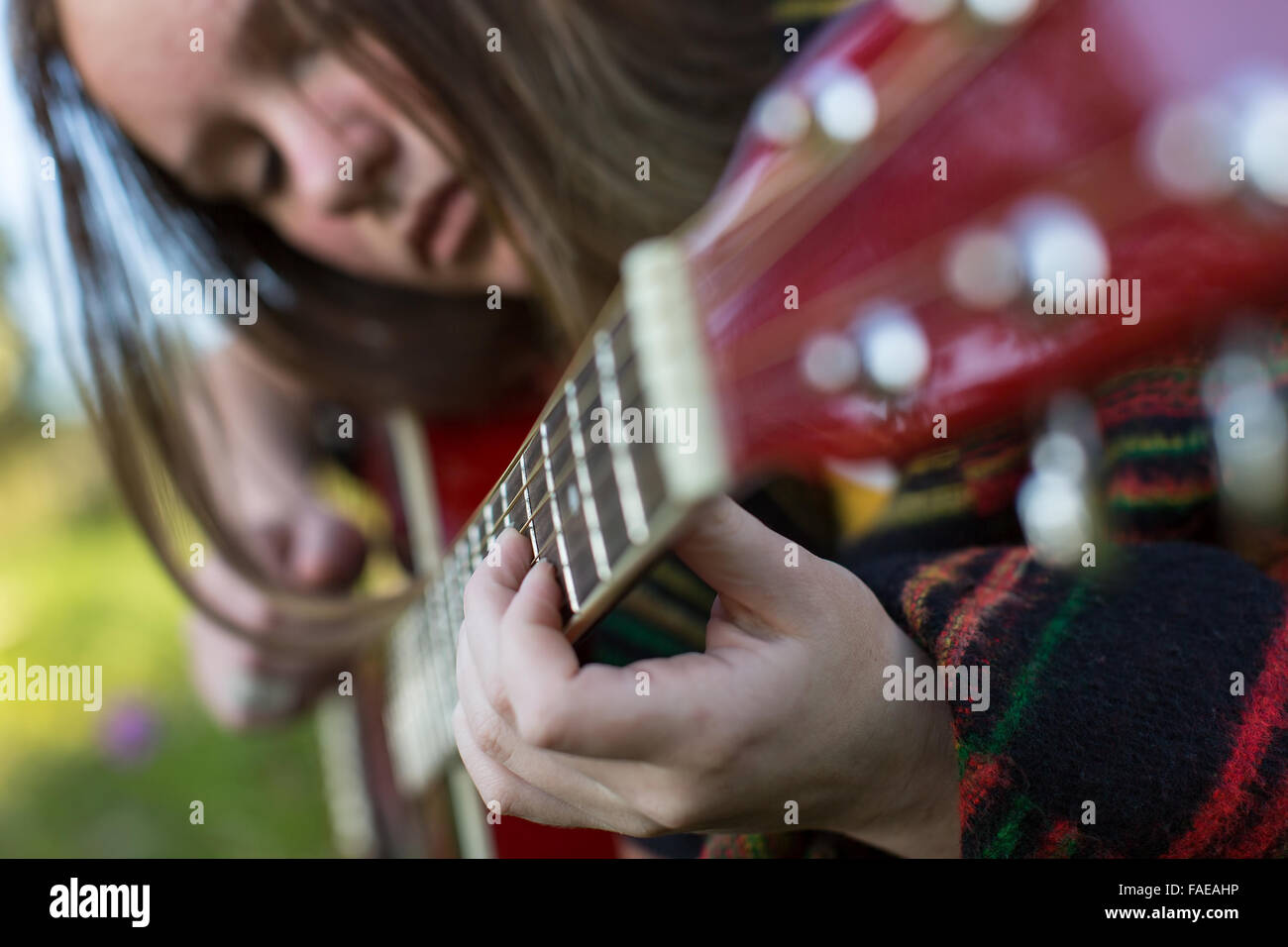Closeup of hands of a young girl playing acoustic guitar. Stock Photo