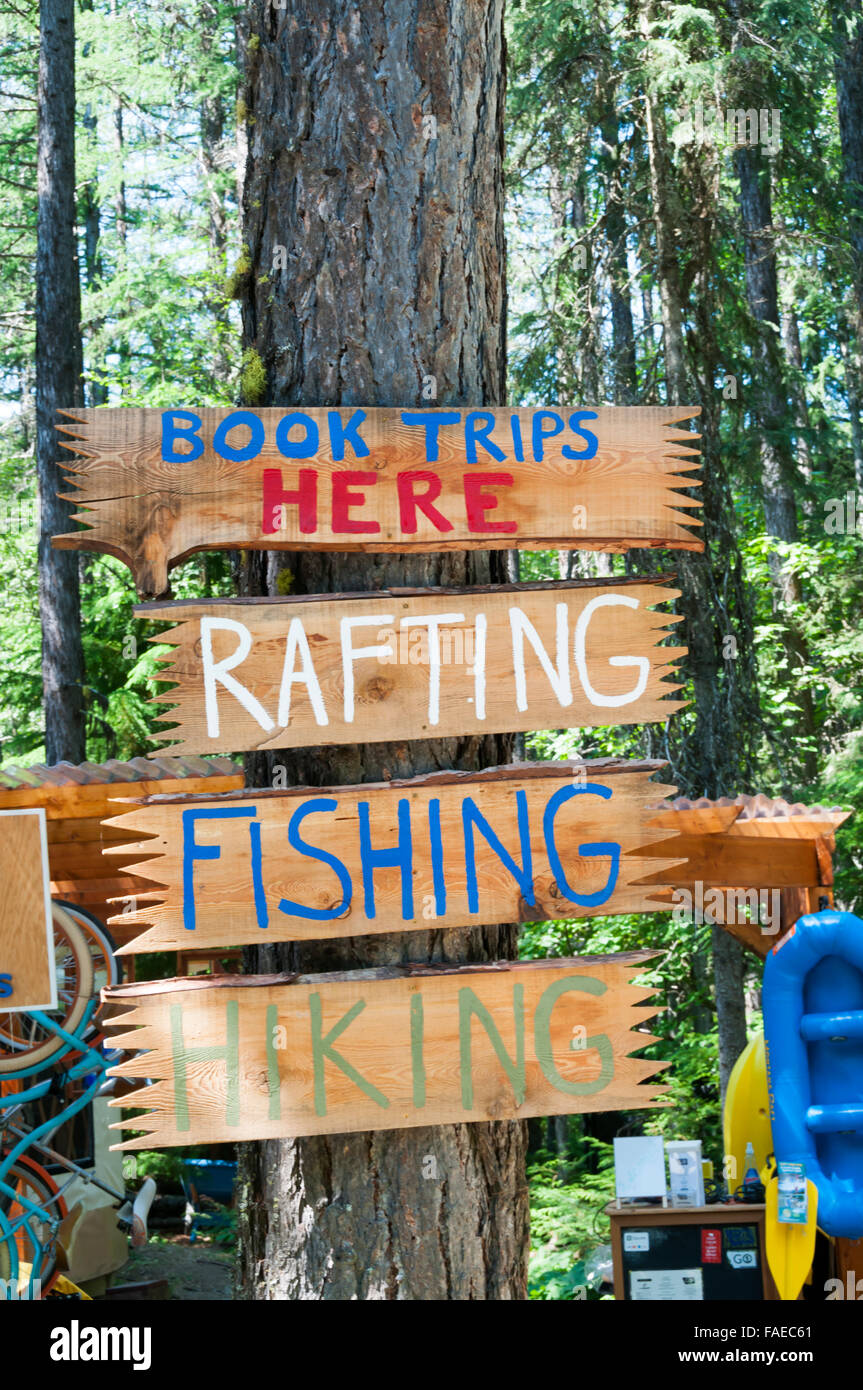 A sign offering Rafting, Fishing and Hiking trips at Apgar village in Glacier National Park, Montana, USA. Stock Photo