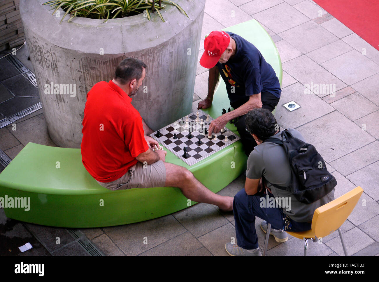 Two males having a game of chess which is being played outdoors in a public space Stock Photo