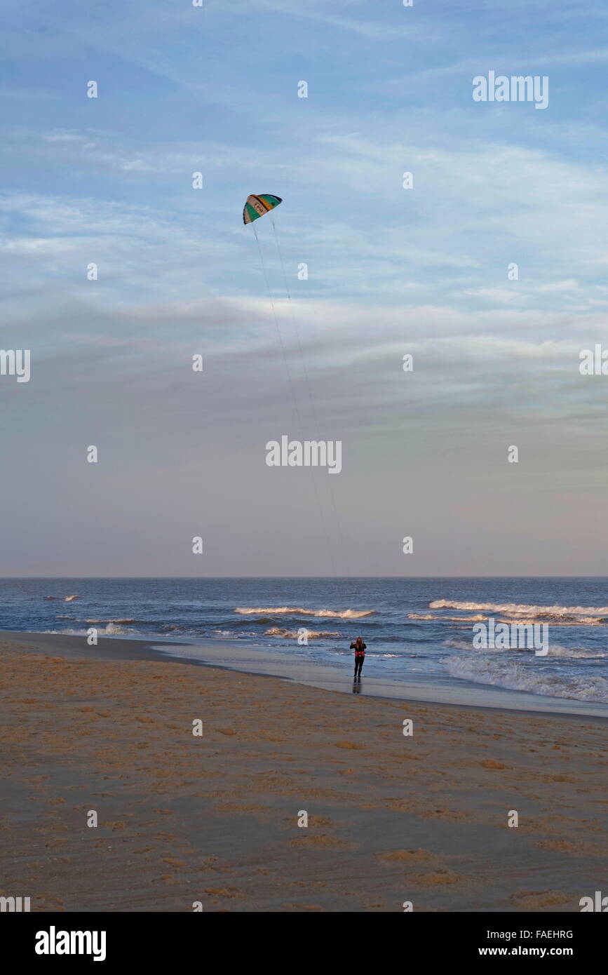 Kite-skimboarder on beach in late afternoon. Stock Photo