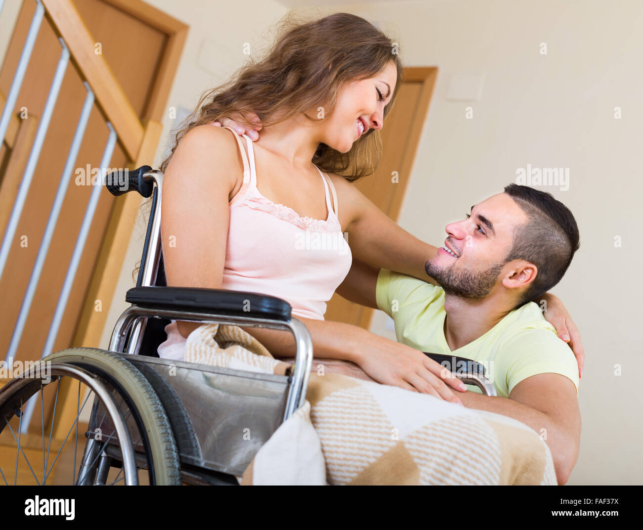 Loving girl in wheelchair with her boyfriend indoor Stock Photo - Alamy