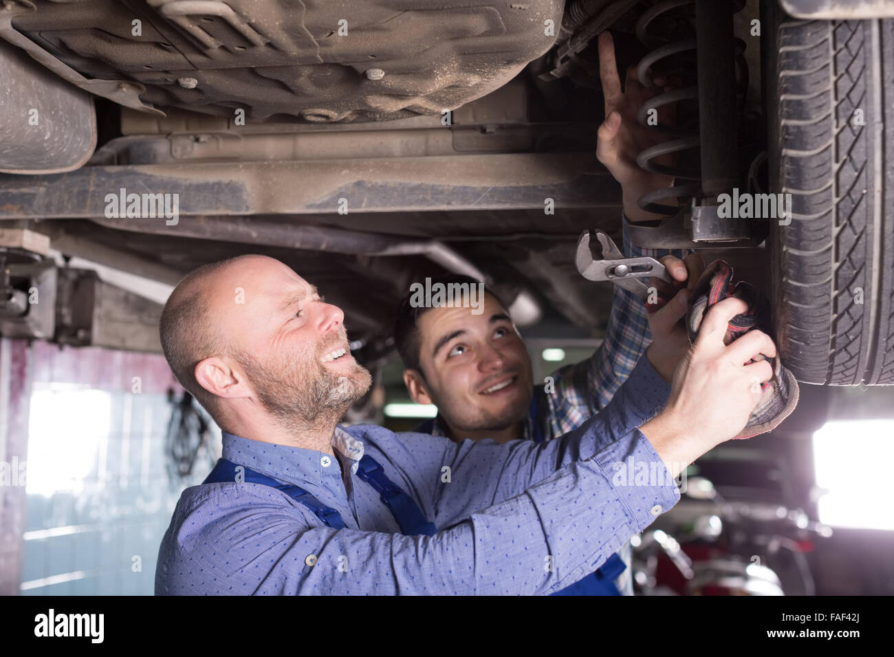 Two Smiling Man Fixing Car Tire Leak Stock Photo - Alamy