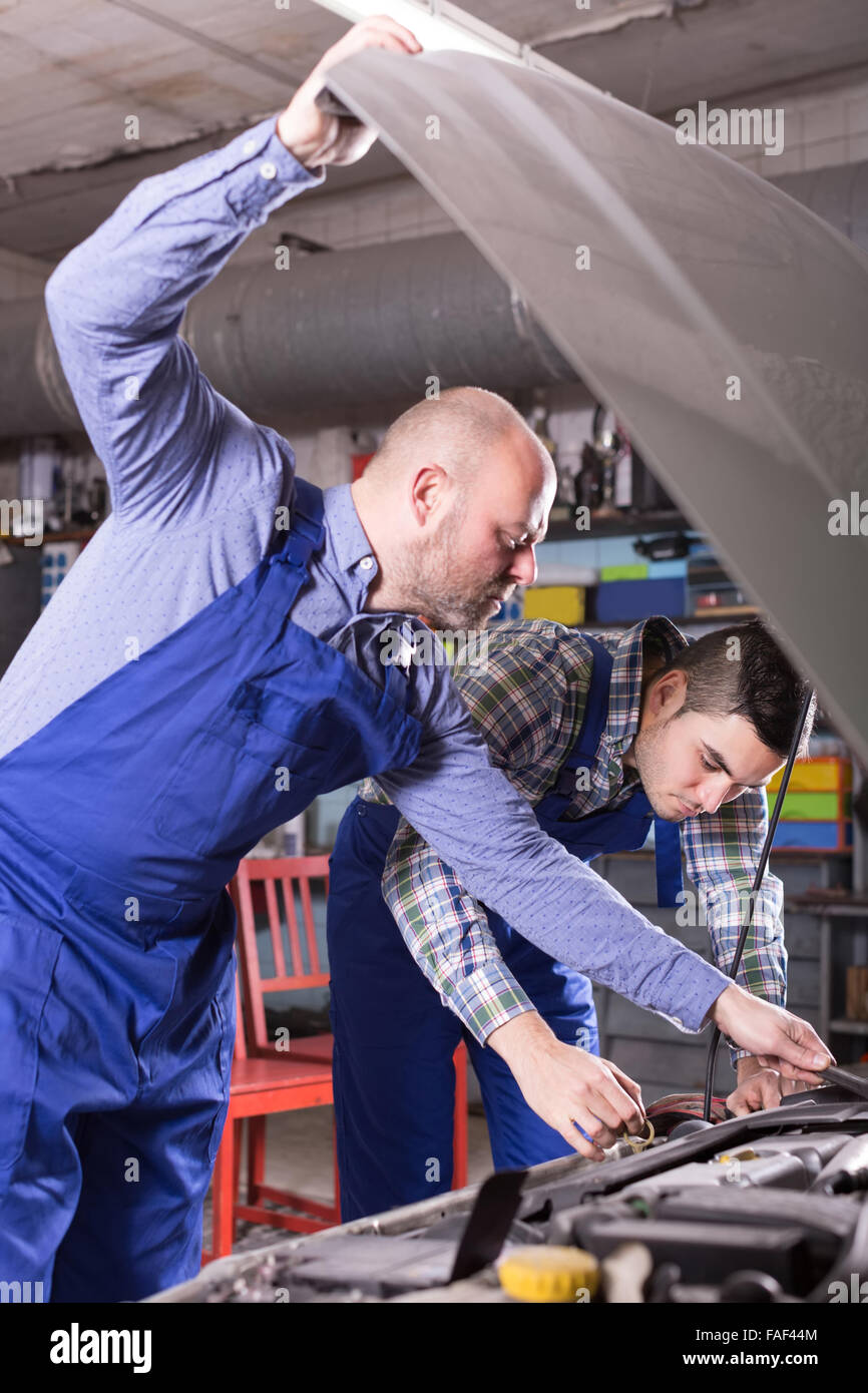 smiling russian car mechanics  working at carshop Stock Photo