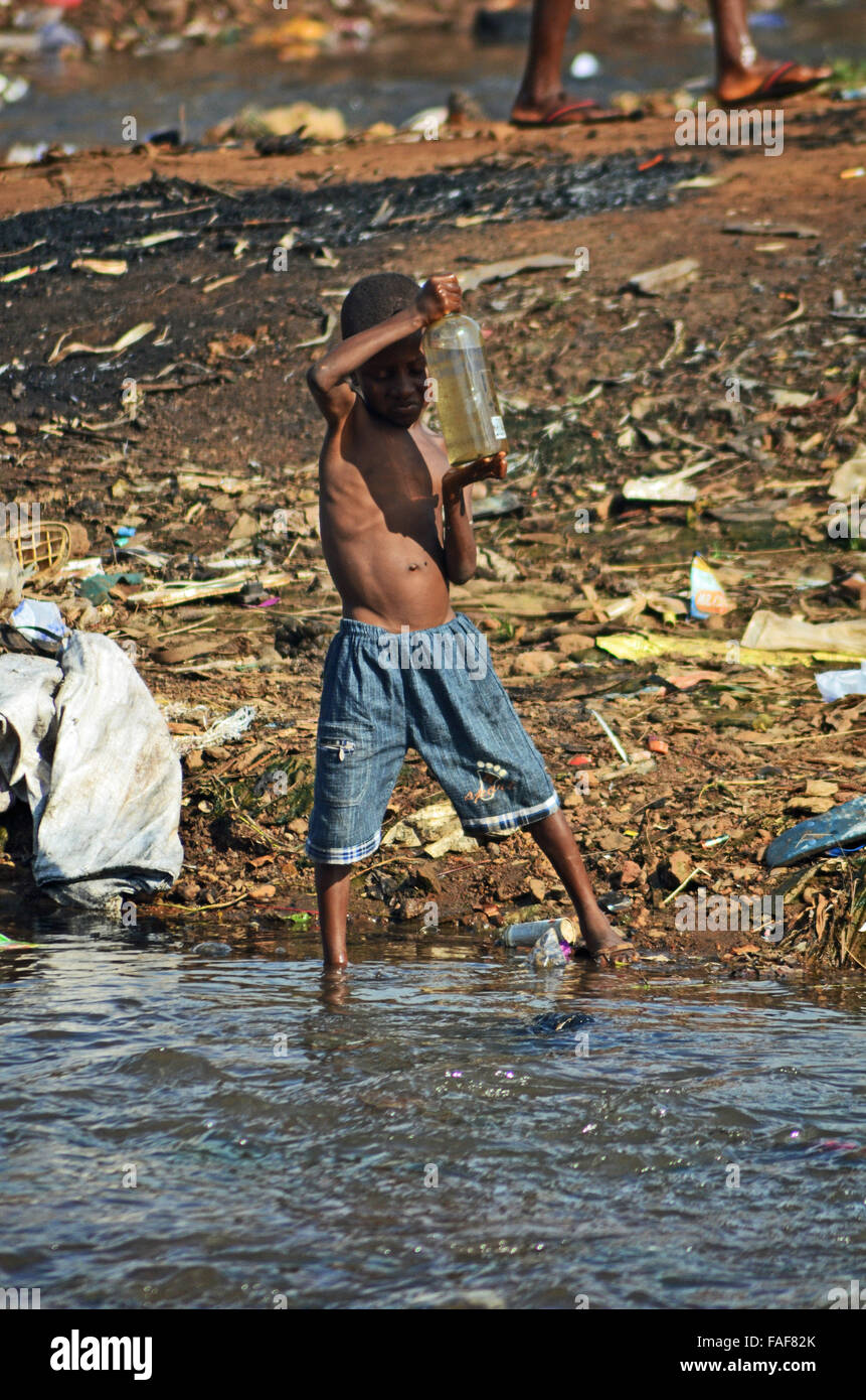Boy collecting dirty water in Kroo Bay, Sierra Leone. Stock Photo