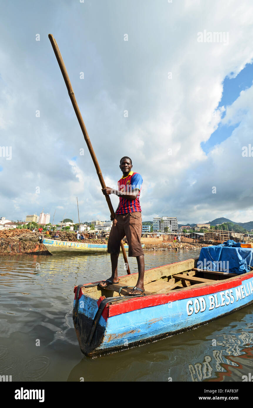 Man on boat in a rubbish dump in Kroo Bay, Freetown, Sierra Leone. Stock Photo