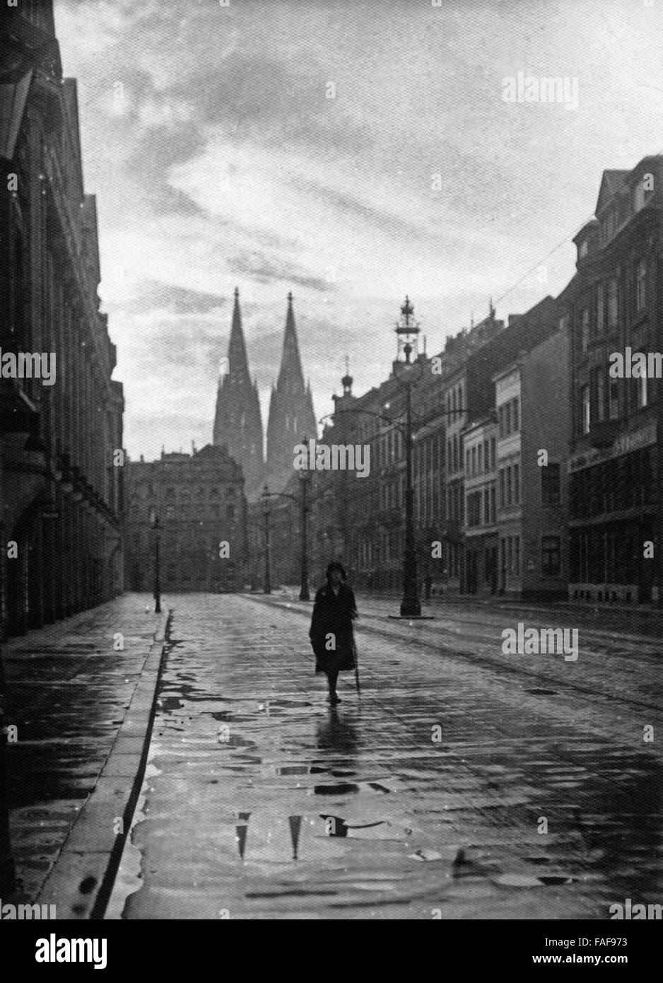 Eine Frau auf der Straße Unter Sachsenhausen nach einem Regenschauer in Köln, Deutschland 1920er Jahre. A woman on the street Unter Sachsenhausen at Cologne after a rain shower, Germany 1920s. Stock Photo
