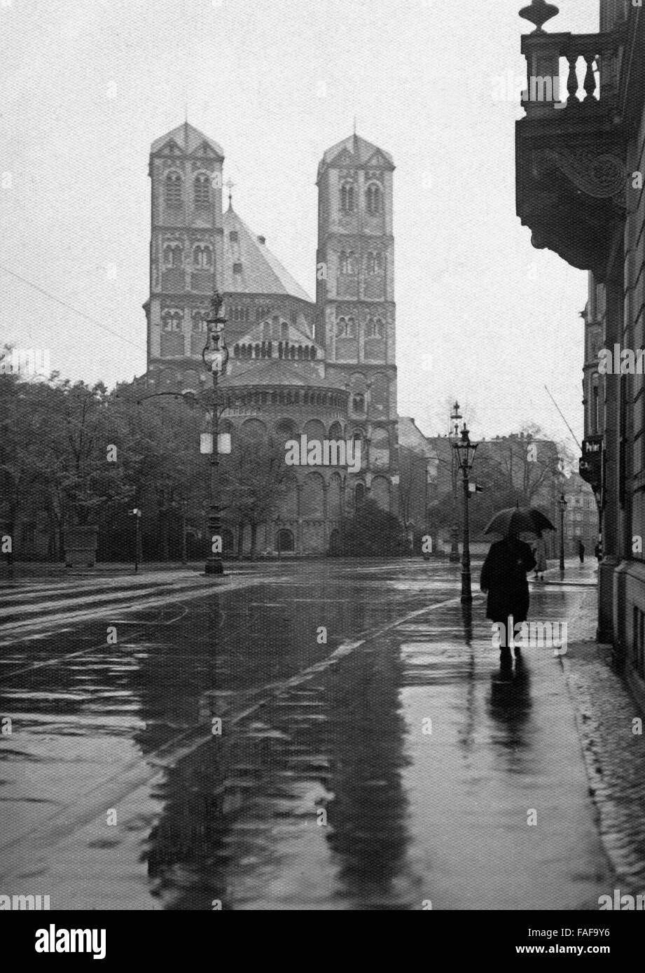 Ein Mann spaziert im Regen vor der Kirche St. Gereon in der Innenstadt von Köln, Deutschland 1920er Jahre. A man walking in the rain in front of St. Gereon's church at the inner city of Cologne, Germany 1920s. Stock Photo