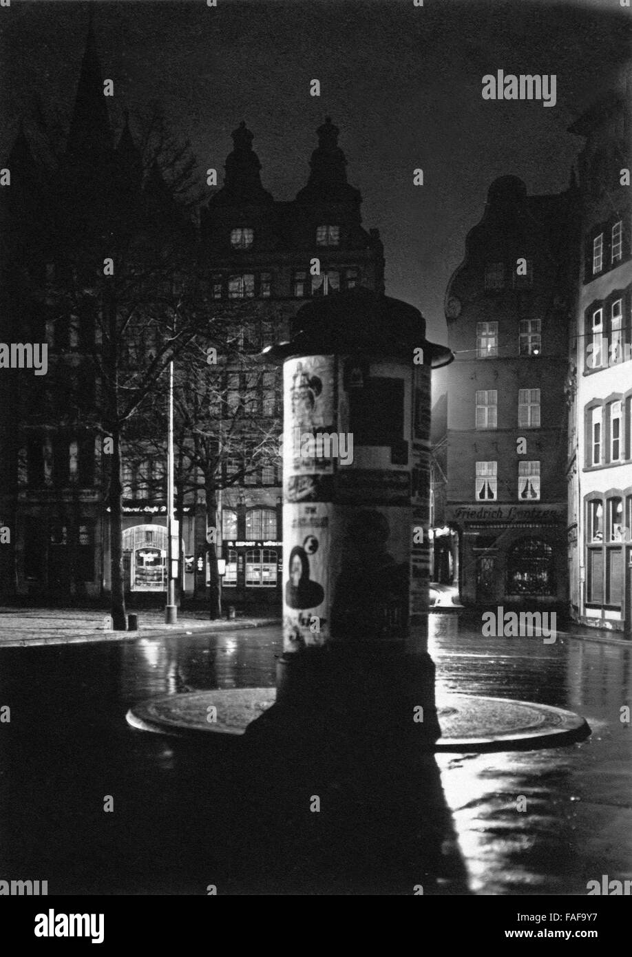 Eine Litfaßsäule auf dem Alter Markt in Köln bei Nacht, Deutschland 1920er Jahre. An advertising column on the Alter Markt market in the old city of Cologne, Germany 1920s. Stock Photo