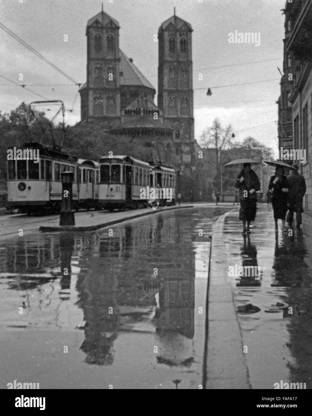 Gereonstraße und Kirche St. Gereon in der Innenstadt von Köln im Regen, Deutschland 1930er Jahre. Gereonstrasse street and St. Gereon's church at Cologne city centre in the rain, Germany 1930s. Stock Photo