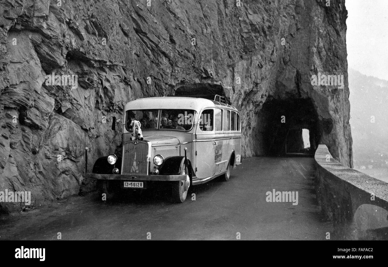 Reisegruppe der Kölner Reisegesellschaft Friedrich Höchstenbach auf der Achsenstraße im Kanton Uri, Schweiz 1930er Jahre. Coach  of Cologne based travel company Friedrich Hoechstenbach on a mountain road at Uri canton, Switzerland 1930s. Stock Photo