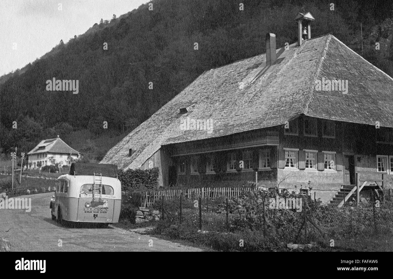 Reisebus der Heimatfreunde Köln vor einem Schwarzwaldhaus, Deutschland 1930er Jahre. Coach of Heimatfreunde club of Cologne in front of a typical Black forest house, Germany 1930s. Stock Photo