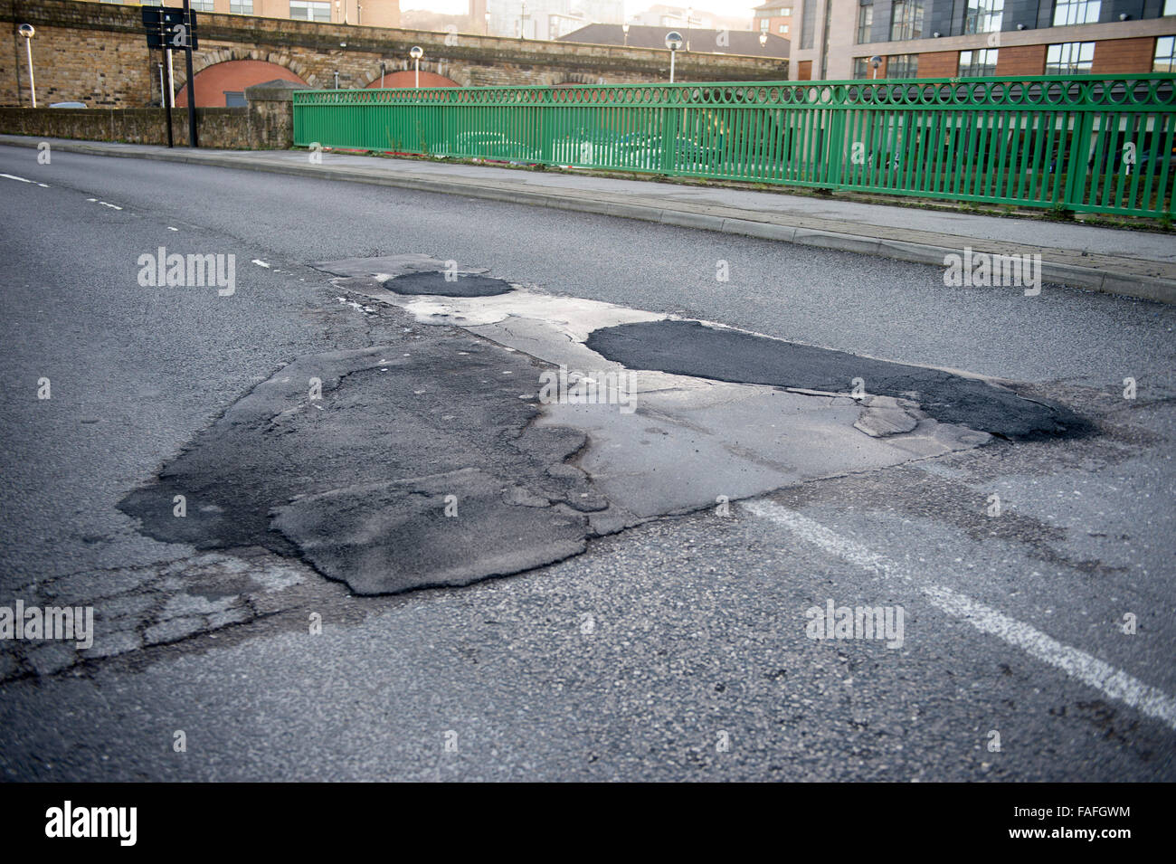 An example of a potholed and repaired road in the city of Sheffield in South Yorkshire on Derek Dooley Way Stock Photo
