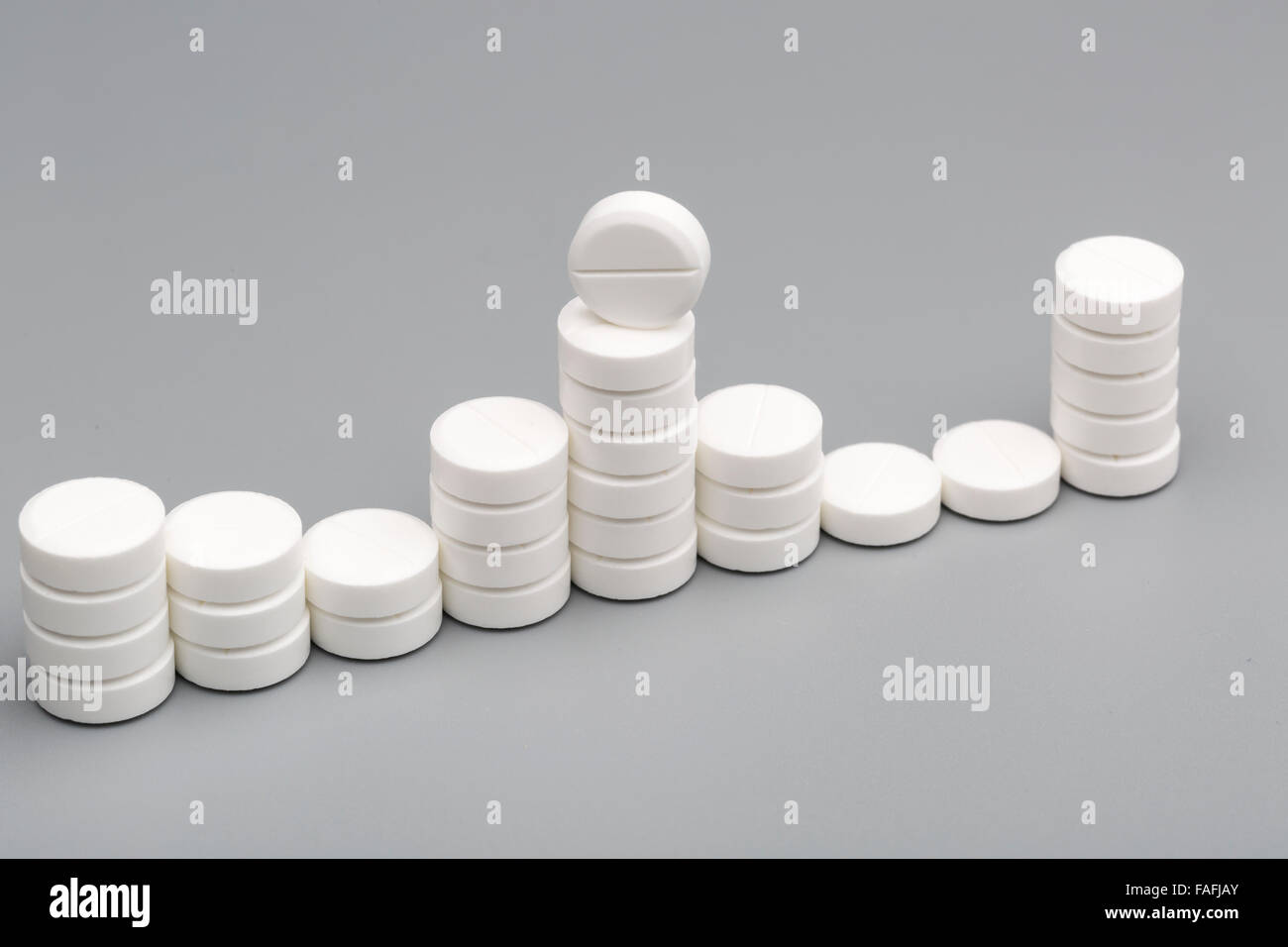 Abstract chart of white pills on a gray background Stock Photo