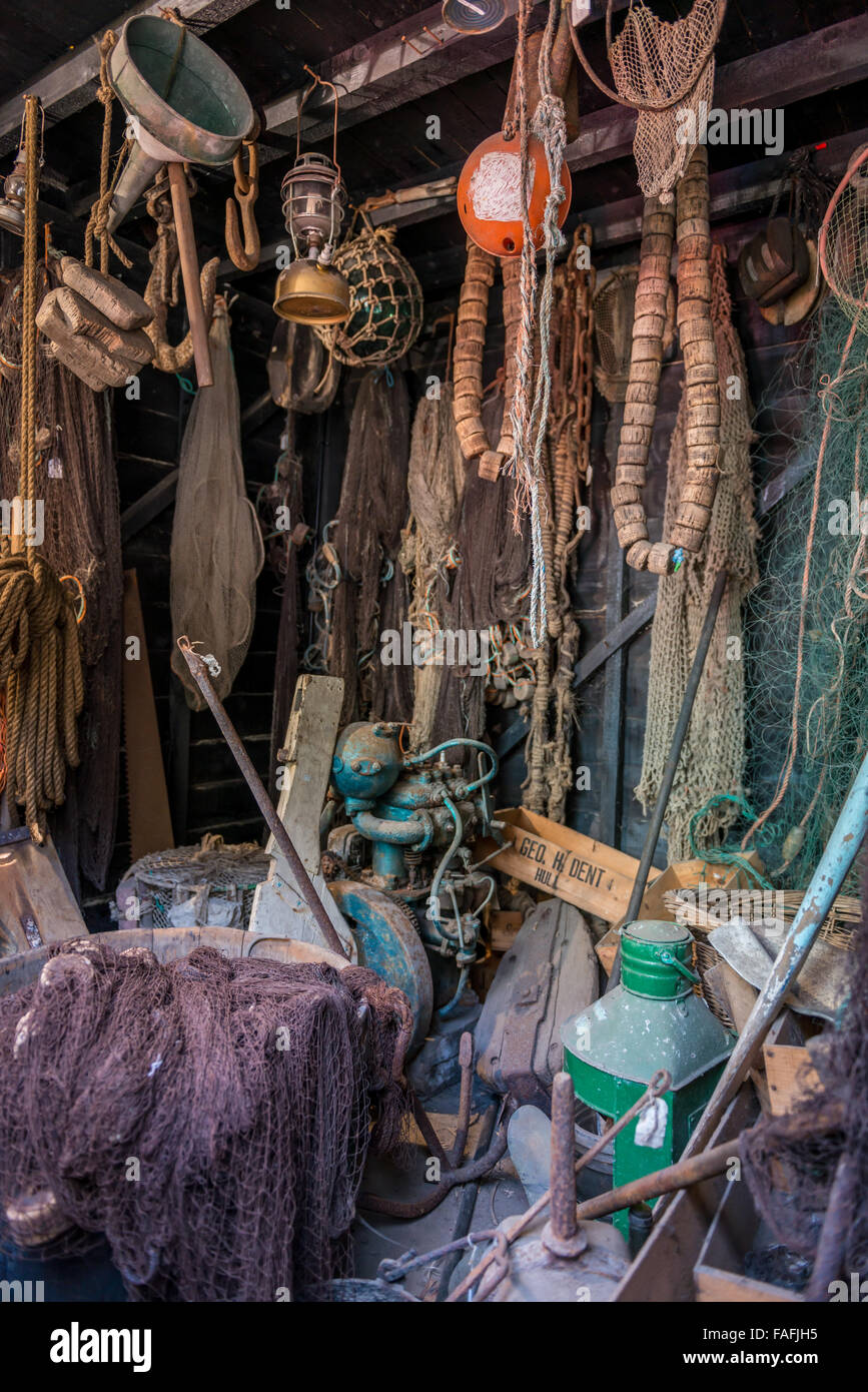 inside a cluttered fisher man's wooden hut by beach Stock Photo