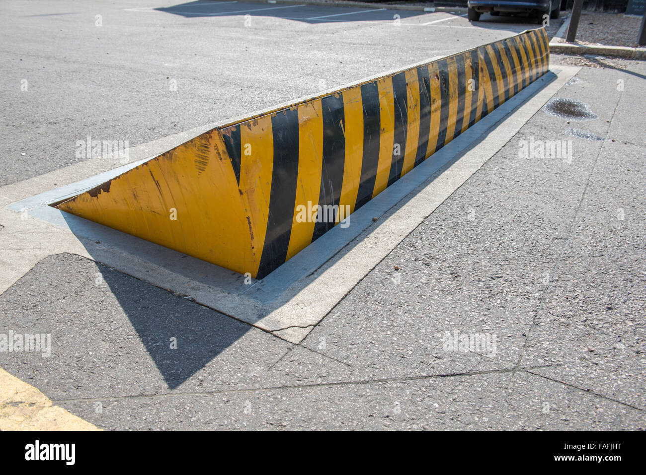 Raised road ramp with yellow and black strip warning Stock Photo