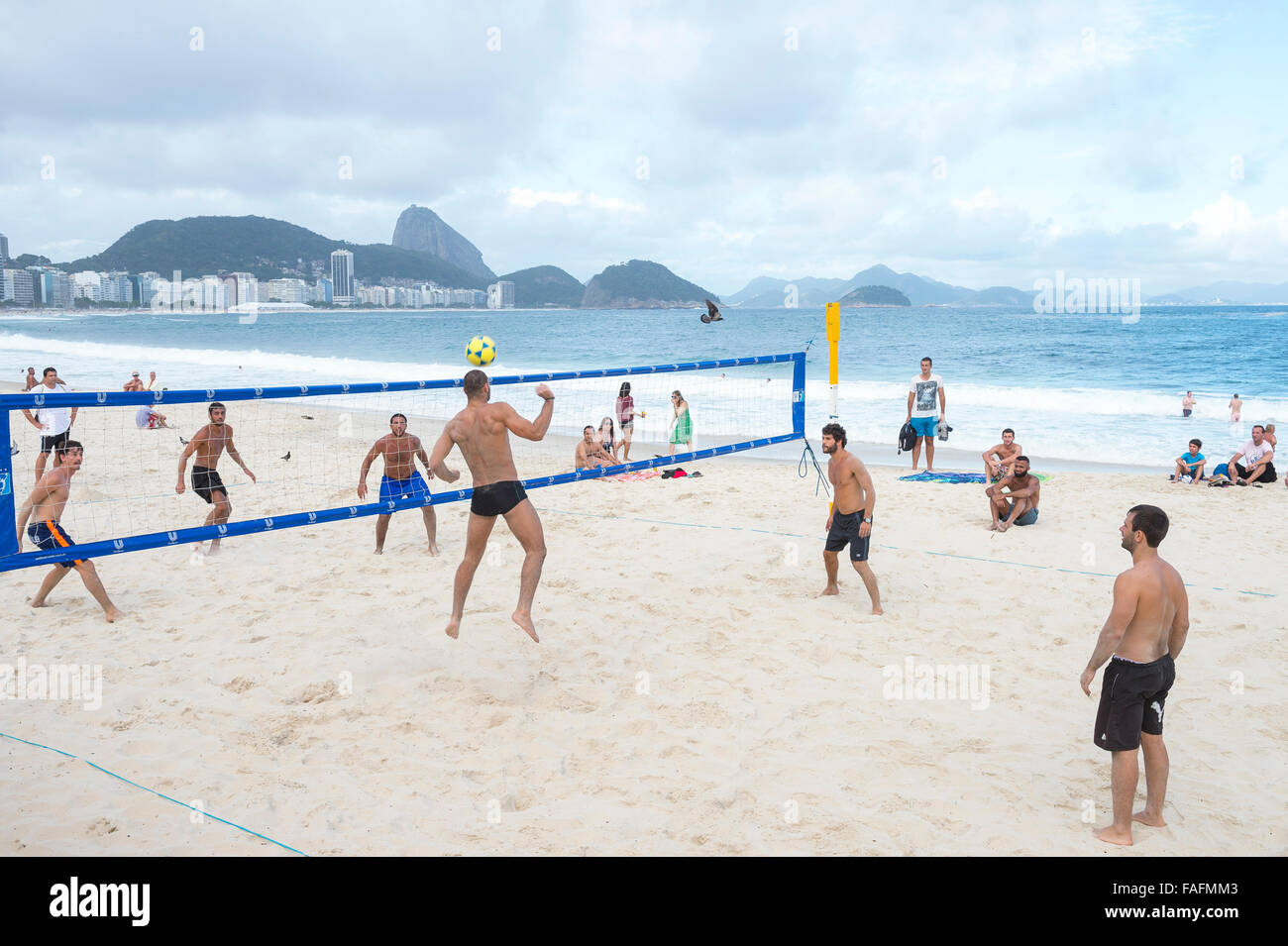 RIO DE JANEIRO, BRAZIL - NOVEMBER 10, 2015: Young Brazilian men play a game of footvolley, combining football and volleyball. Stock Photo