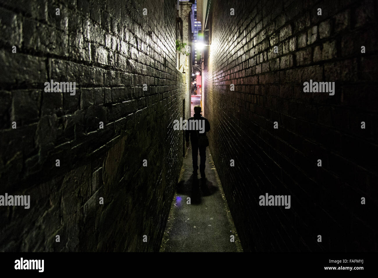 Silhouette of an unrecognizable man walking in one of the many alleways in Melbourne, Australia. Stock Photo