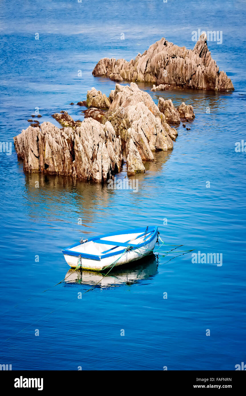boat moored next to a rock in the harbor Stock Photo - Alamy
