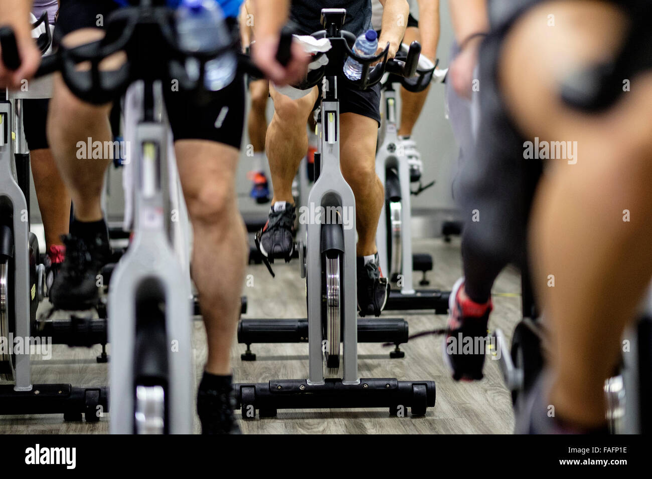 People riding stationary bicycles during a spinning class at the gym Stock Photo