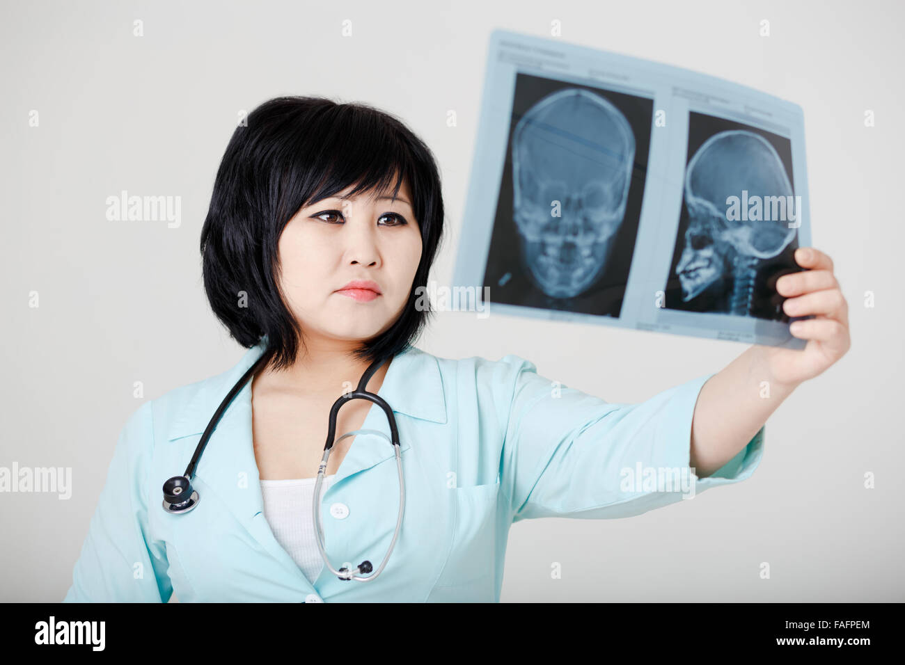 Young Female Asian Doctor With Stethoscope Looking At The X Ray Stock Young Female Asian Doctor With Stethoscope Looking At The X Ray Stock