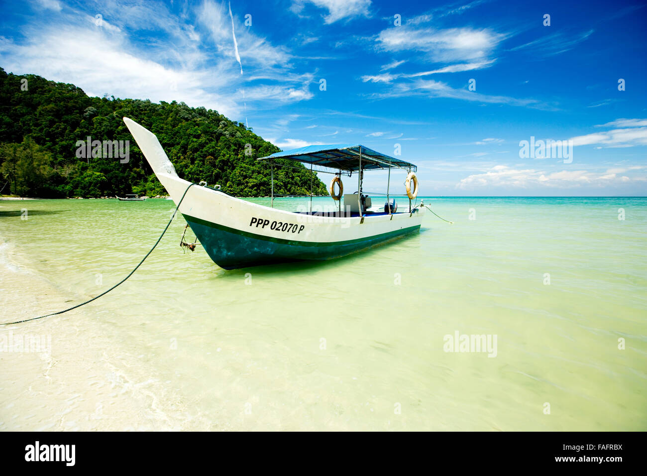 Long boat moored on a beach in thailand Stock Photo
