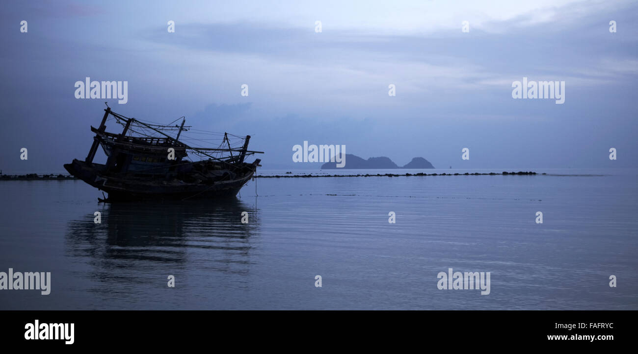 Fishing boat stranded on the beach with islands in distance,koh phangan, Thailand. Stock Photo