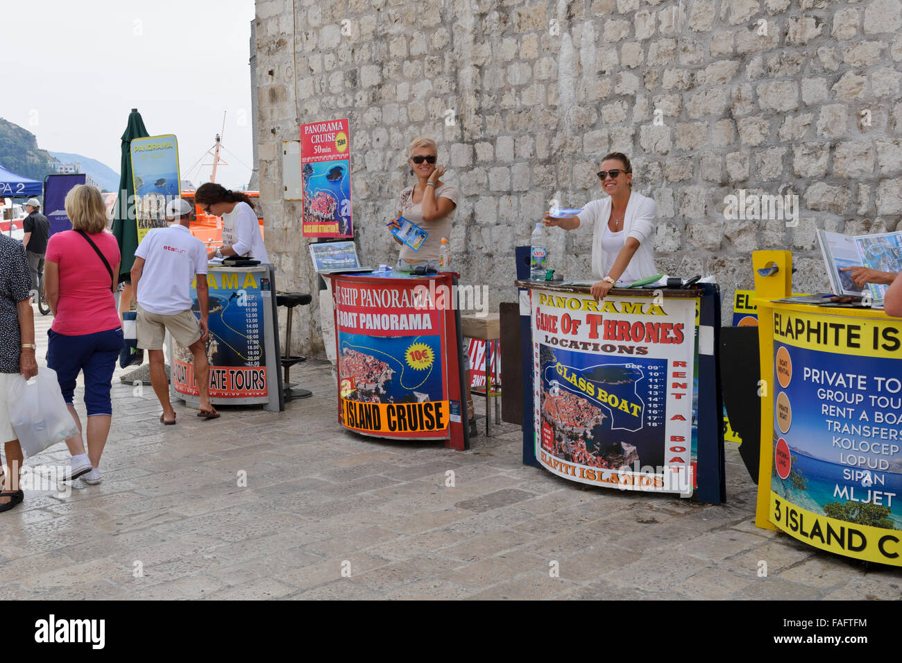 Tour agents selling touring tickets to tourists by the harbour in Dubrovnik, Croatia. Stock Photo