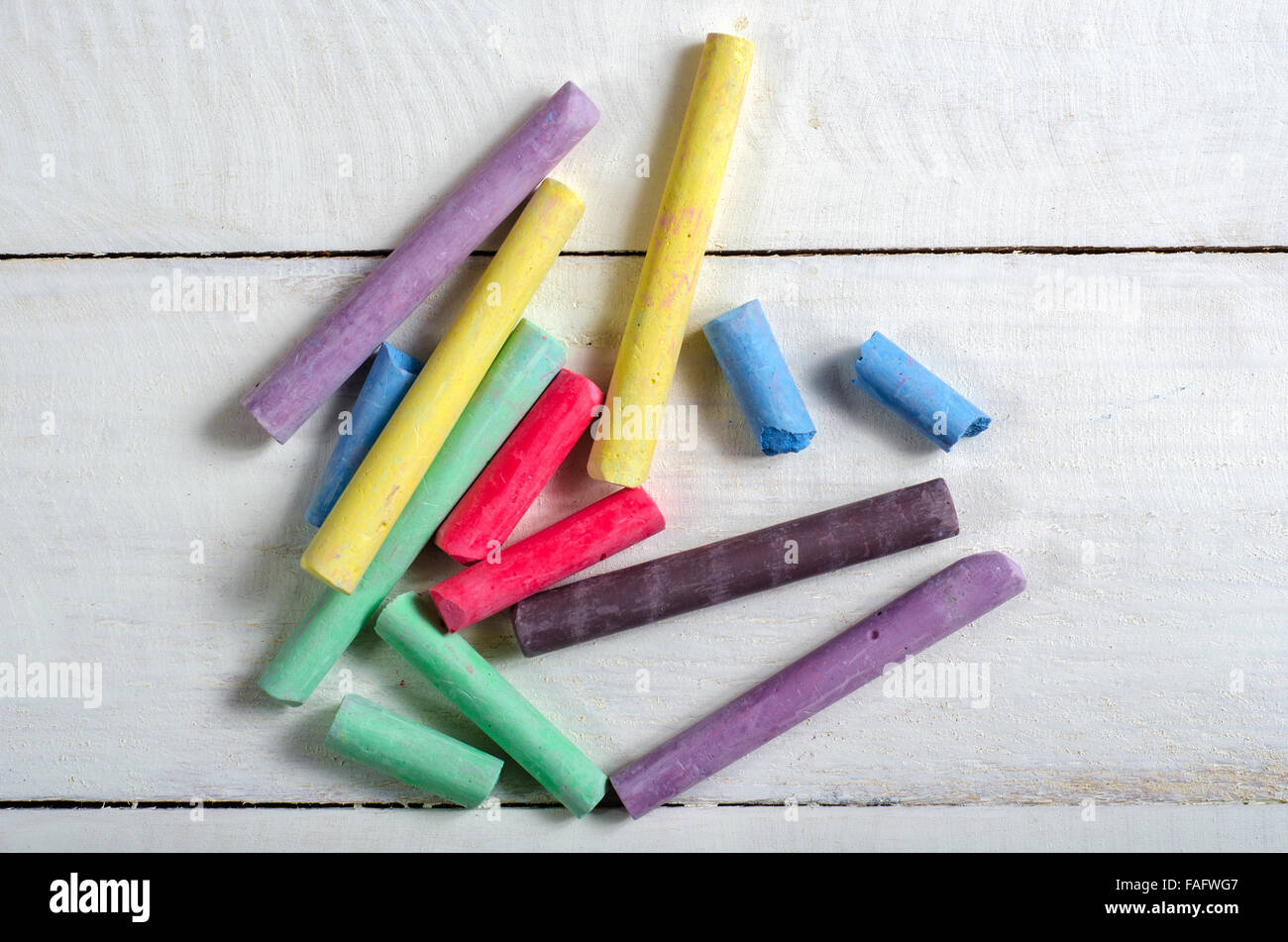 Top view of lots of multicolored chalk on white wooden table Stock Photo