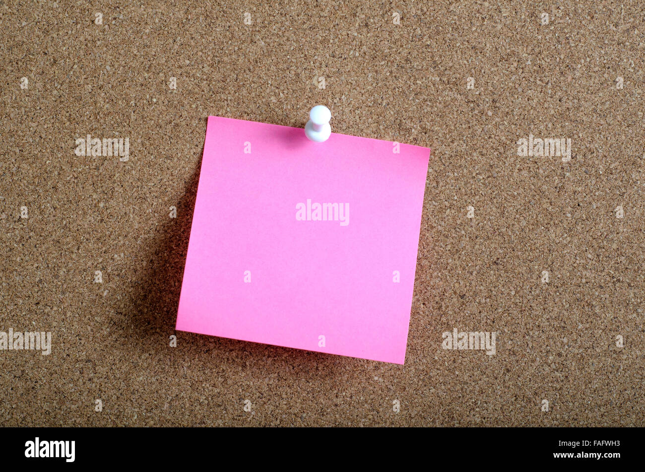 Reminder sticky note on cork board in close up Stock Photo
