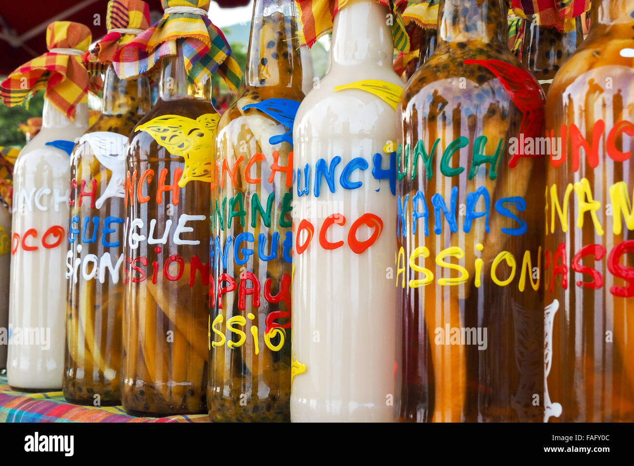 Traditional flavoured rum bottles on the desk of a market stall in Martinique and Guadeloupe Stock Photo