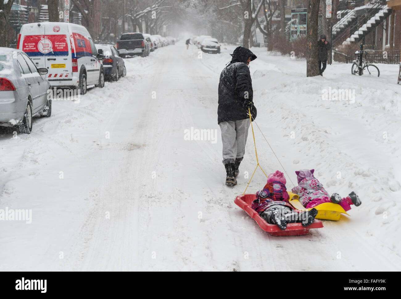 Montreal, Canada. 29th December, 2015. Father and kids enjoy a sleigh ride in Montreal, during first snow storm of the season. Credit:  Marc Bruxelle/Alamy Live News Stock Photo