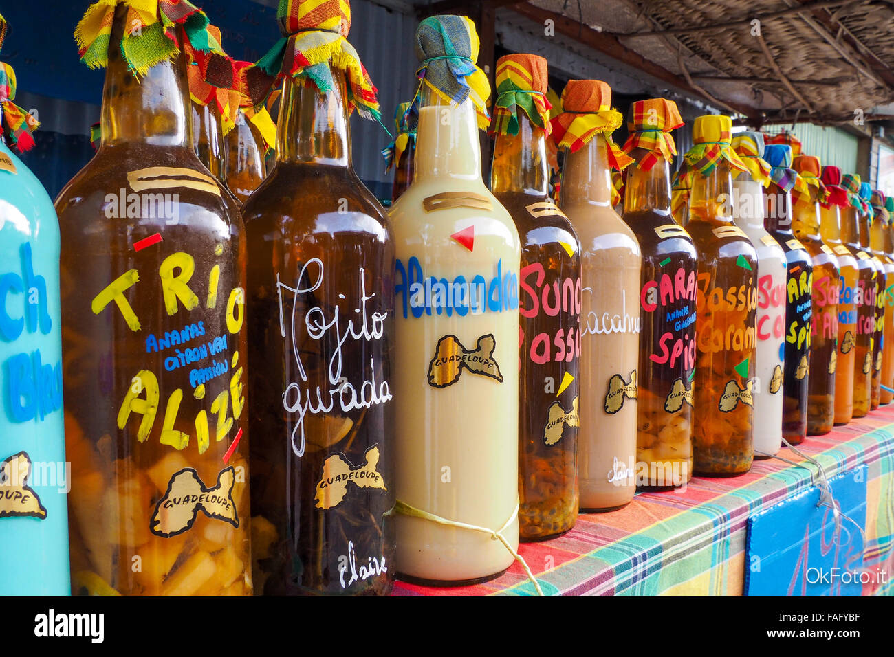 Traditional flavoured rum bottles on the desk of a market stall in Sainte Anne, Guadeloupe Stock Photo