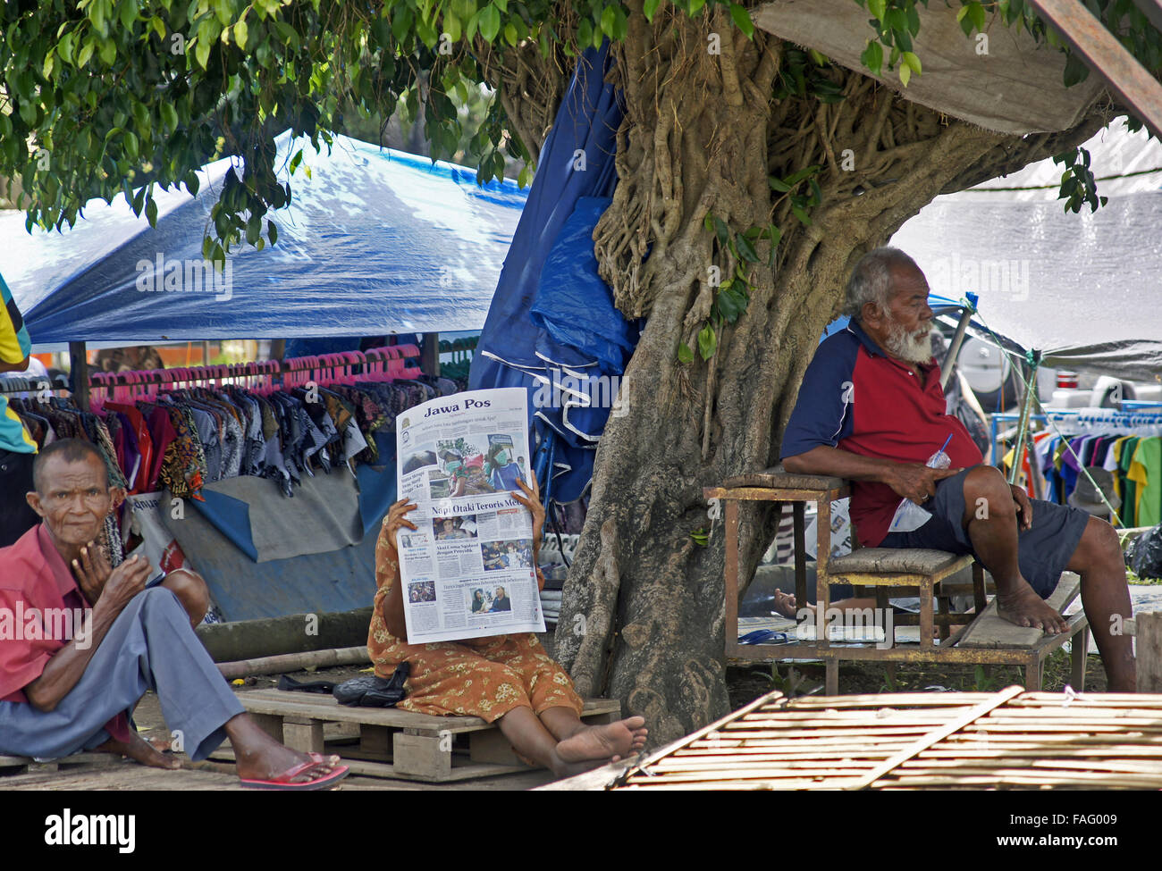 Sitting reading the newspaper in the shade Stock Photo