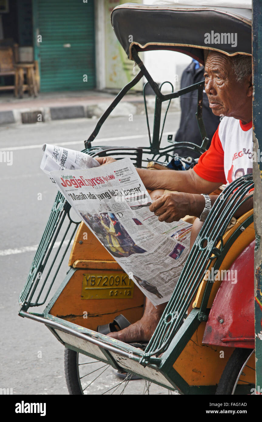 A Becak driver concerned about the nearby Mount Merapi volcano eruption in the area Stock Photo