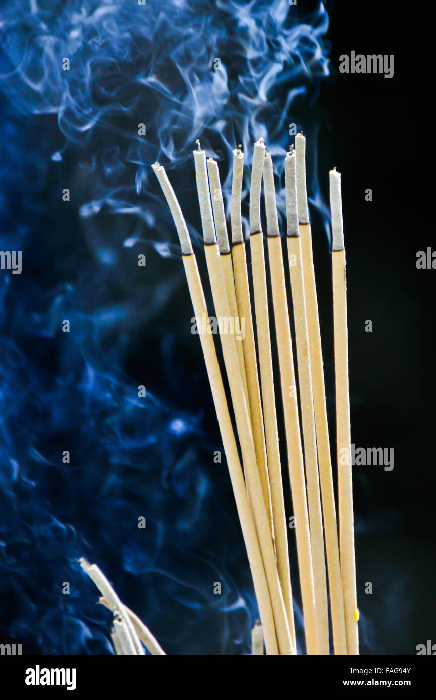 Incense sticks on joss stick pot are burning and smoke use for pay