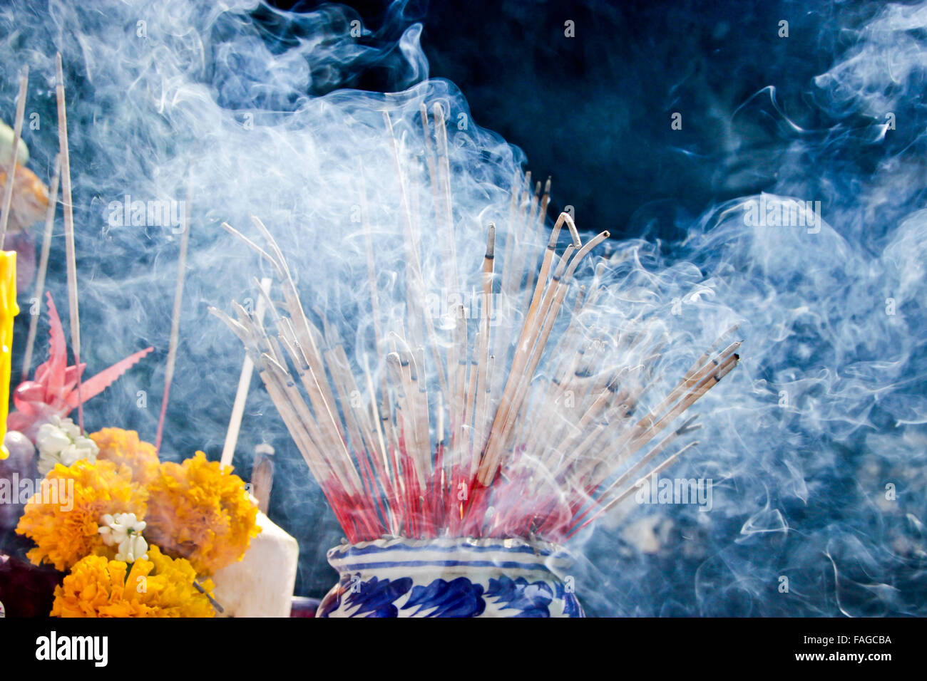 Incense sticks on joss stick pot are burning and smoke use for pay