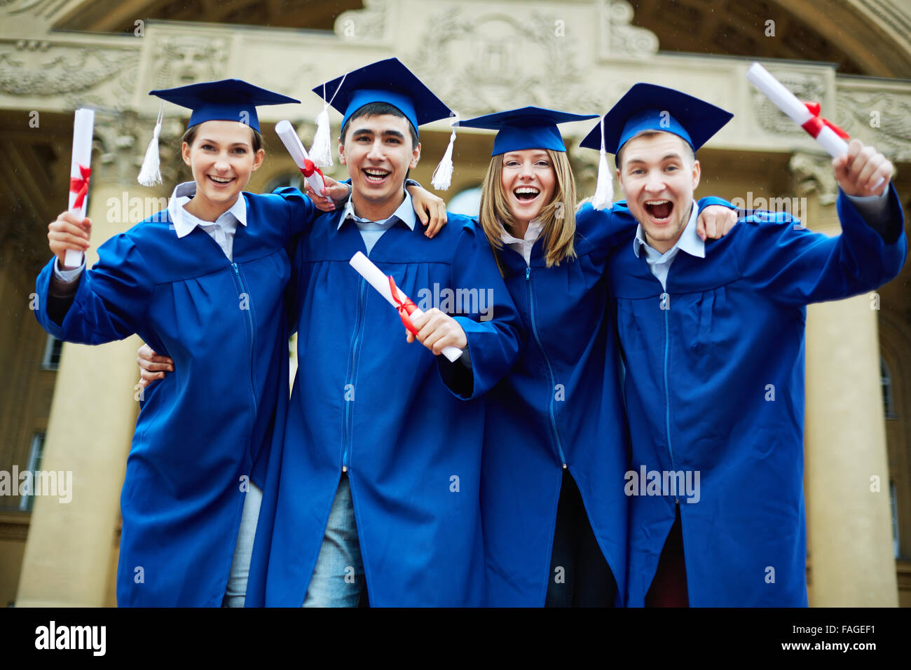 Group of ecstatic graduates with diplomas Stock Photo