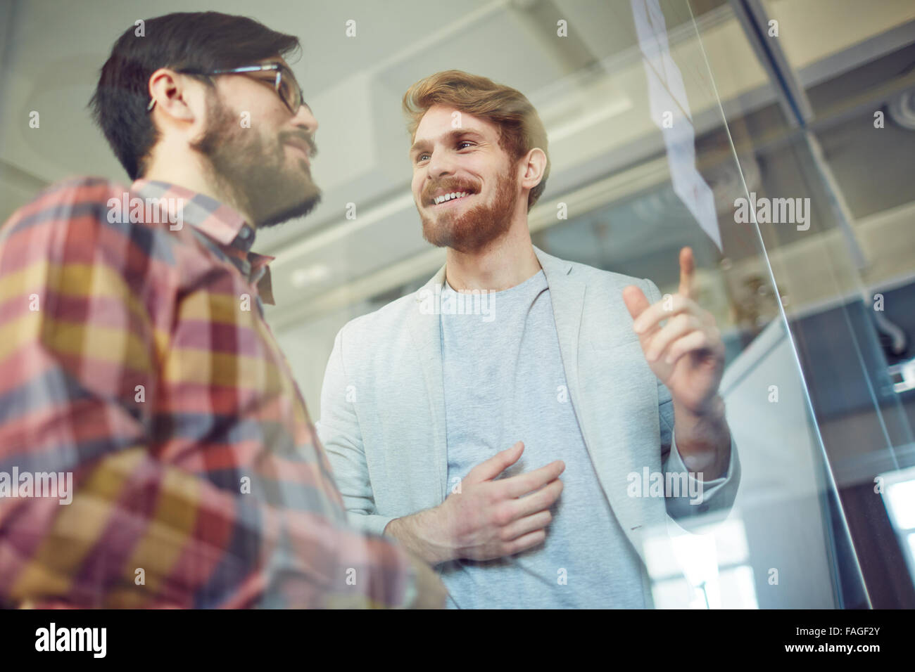 Happy office workers discussing notes at meeting Stock Photo