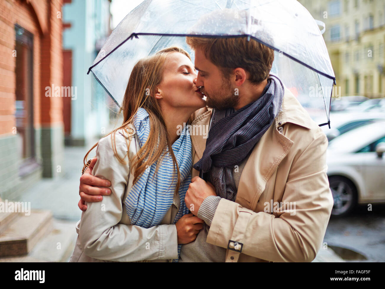 Amorous young couple sharing tender kiss under umbrella Stock Photo Alamy