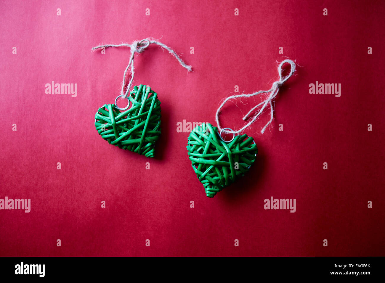 Decorative green hearts with threads on red background Stock Photo - Alamy