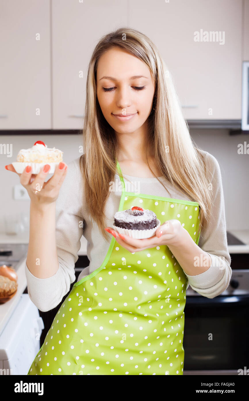 Blonde girl with cakes in kitchen Stock Photo