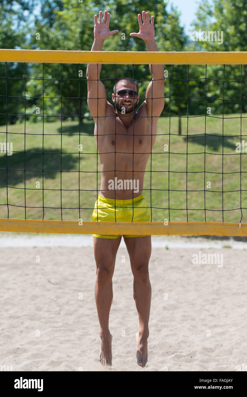 Muscular Young Man Playing Beach Volleyball Diving After The Ball Stock Photo