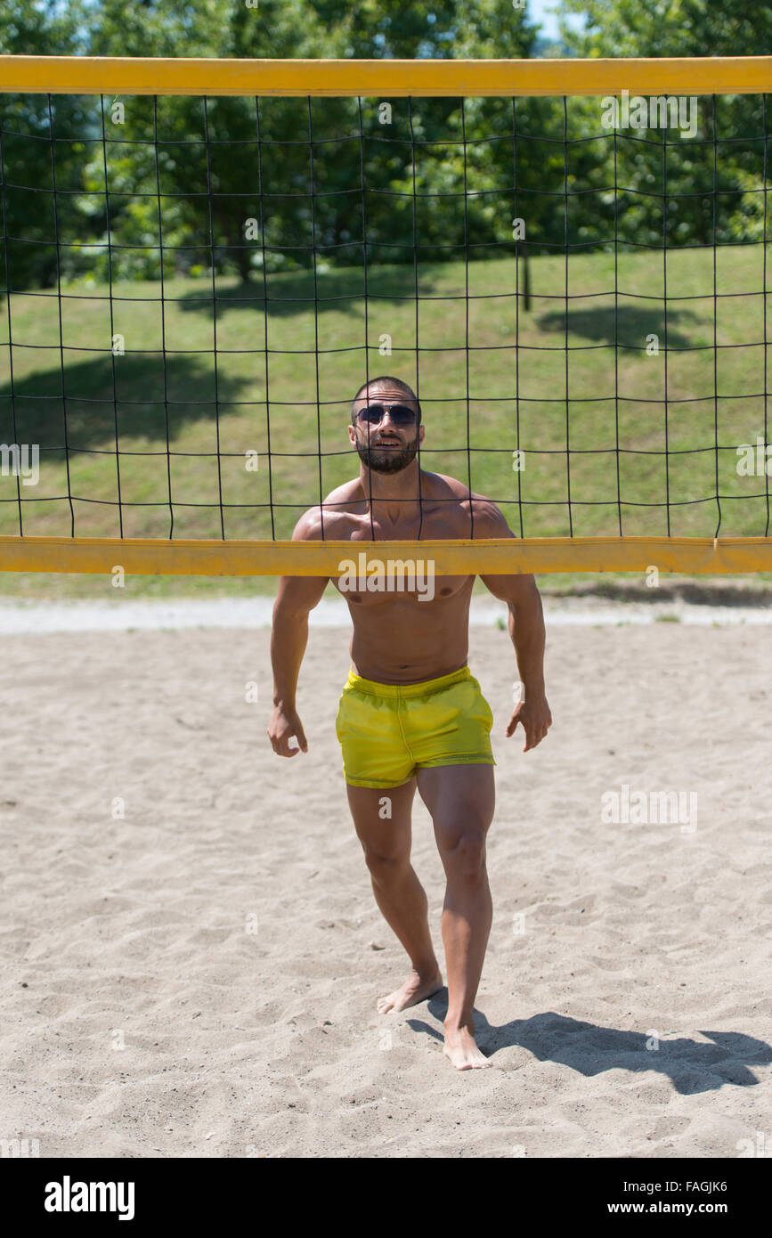 Muscular Young Man Playing Beach Volleyball Diving After The Ball Stock Photo