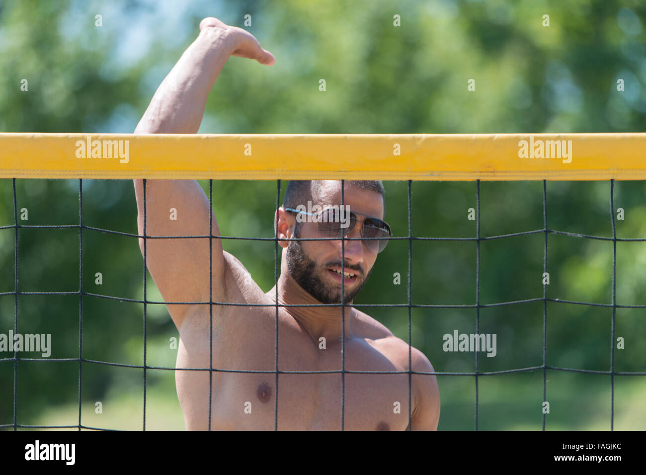 Muscular Young Man Playing Beach Volleyball Diving After The Ball Stock
