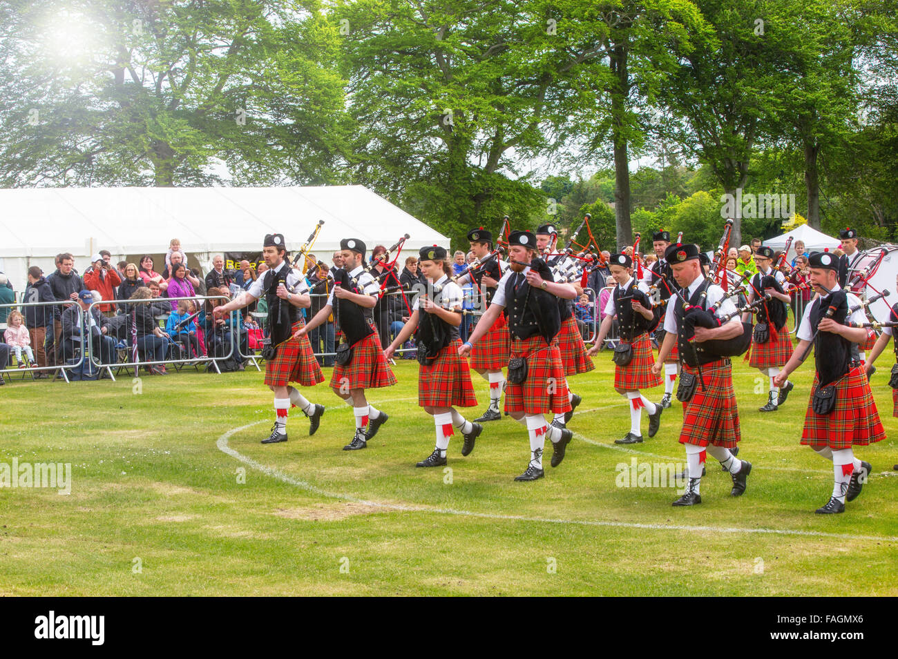 A pipe band marching in kilts at the Highland Games in Aberdeen, Scotland, UK Stock Photo