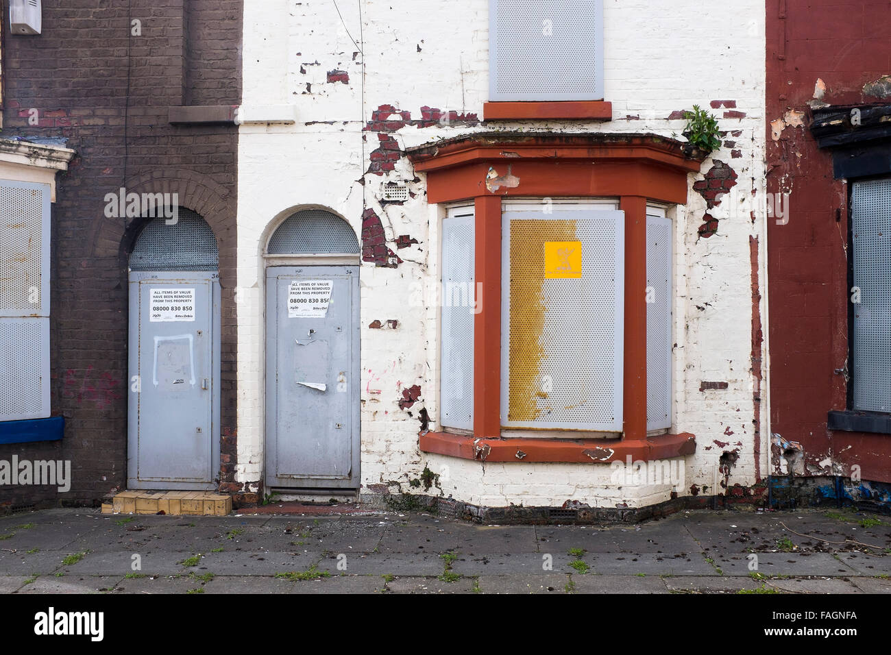 A boarded up house in Liverpool 8 has metal screens on doors and windows to deter vandals and thieves. Liverpool council owns Stock Photo