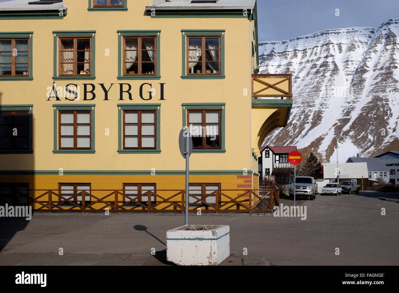 A rental car outside a house in Isafjordur against the dramatic hills and mountains behind in the westfjords of northern Iceland Stock Photo