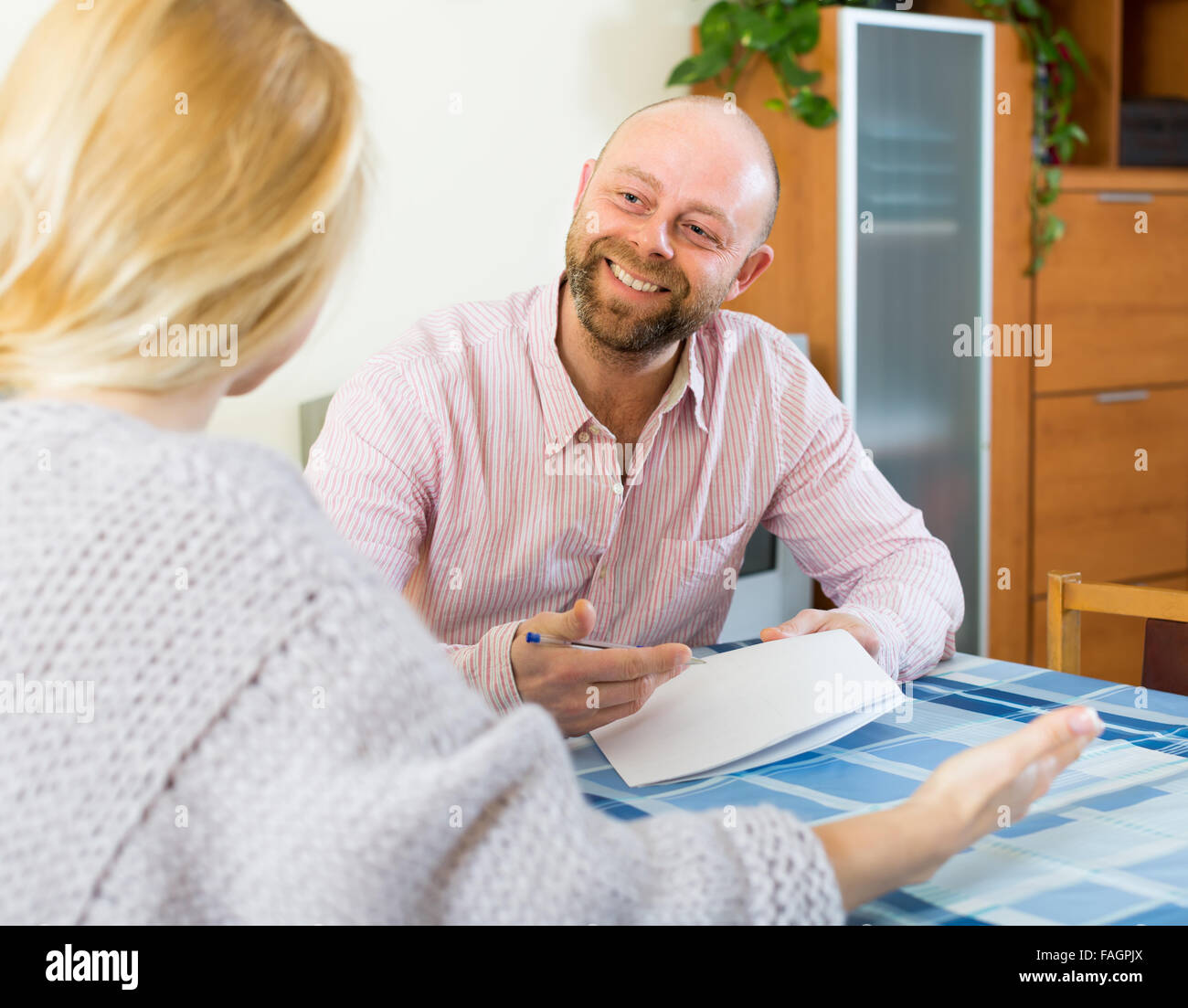 Positive smiling couple discussing details of marriage settlement