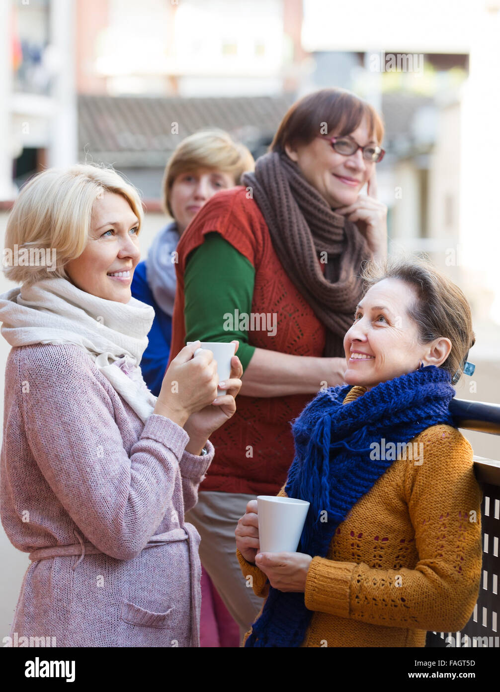 Group of smiling aged female friends drinking tea at balcony Stock ...